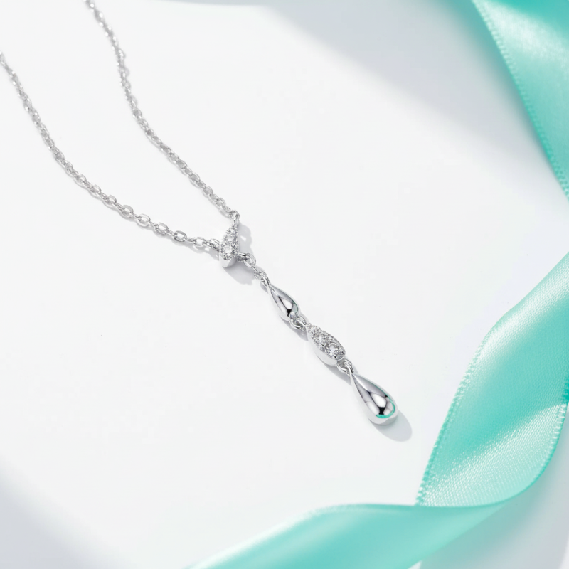Silver necklace with a pendant on a light blue ribbon background