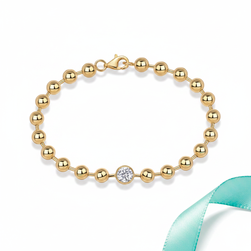 Gold bracelet with a central diamond on a white background