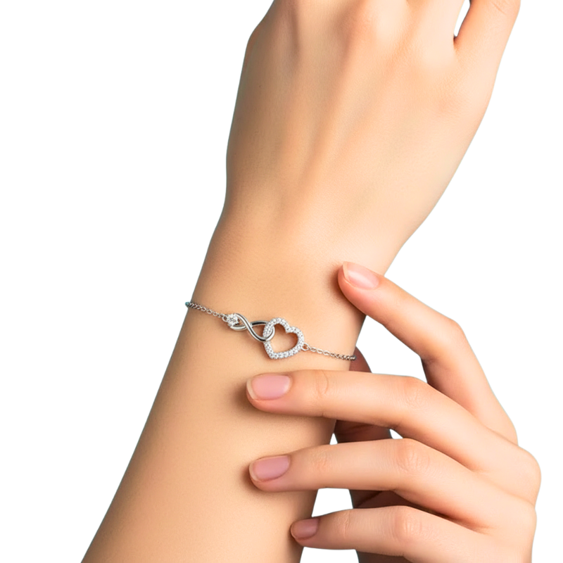 Silver bracelet with a heart design on a wrist against a white background