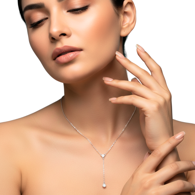 Woman wearing a silver necklace with a heart-shaped pendant on a neutral background