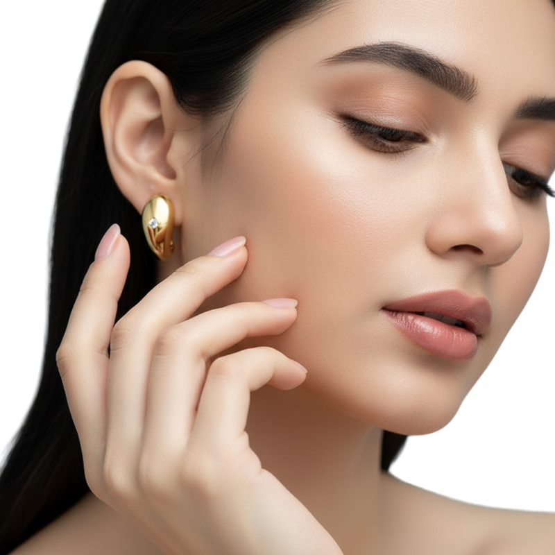 Close-up of a woman wearing a gold earring with a neutral background