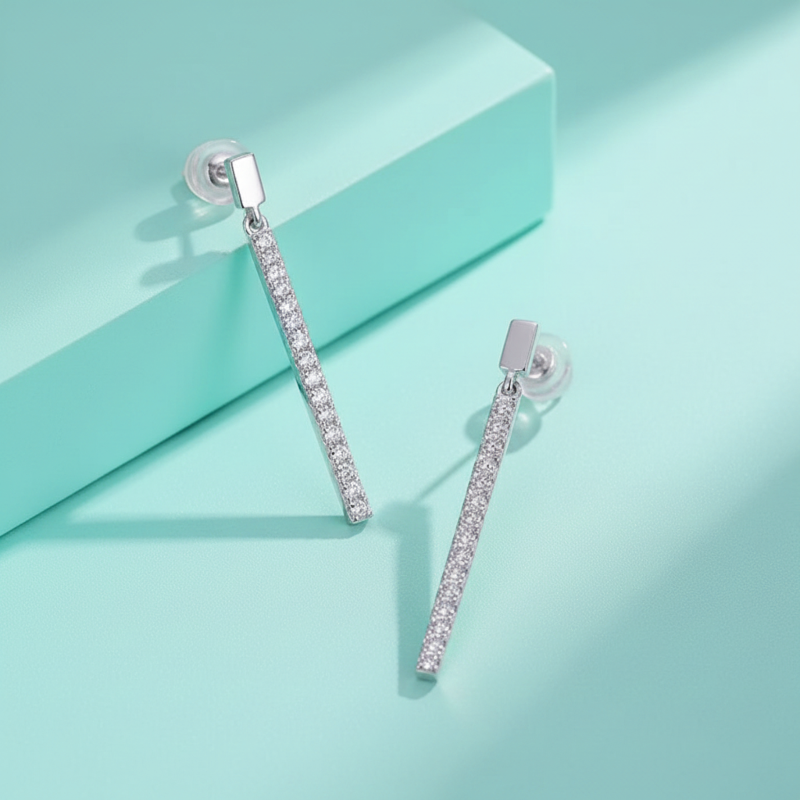 Silver earrings with clear stones on a light blue background