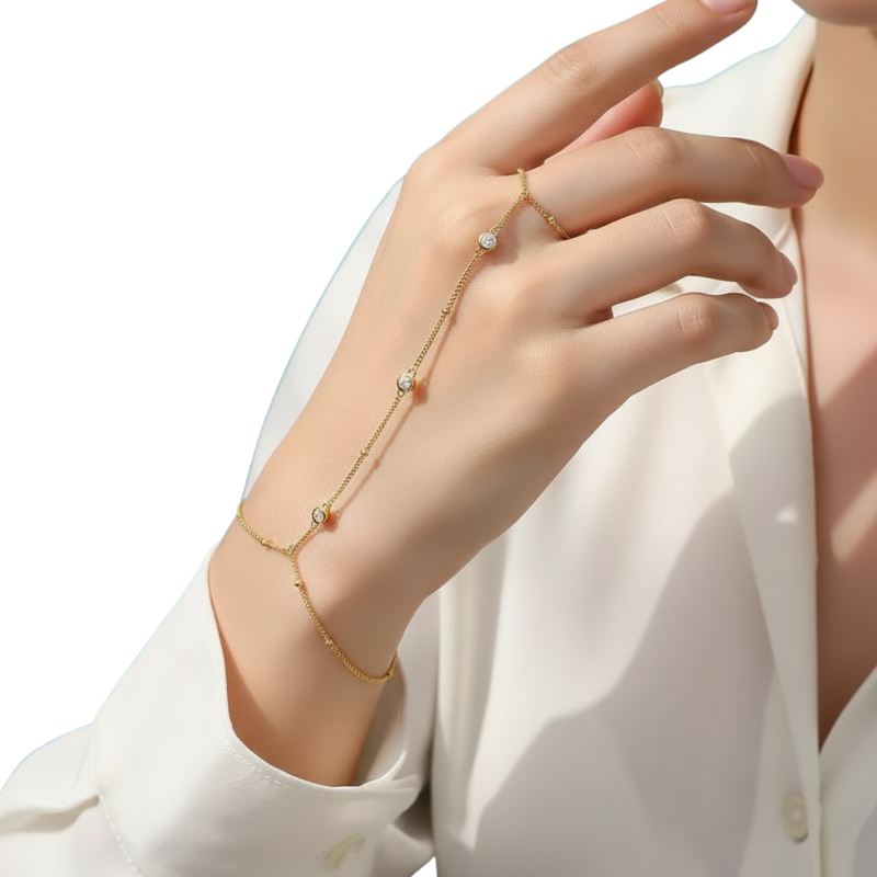 Hand wearing a delicate gold bracelet with small beads on a white background
