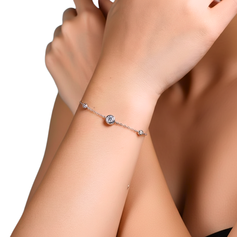 Silver bracelet with a central gemstone on a wrist against a neutral background