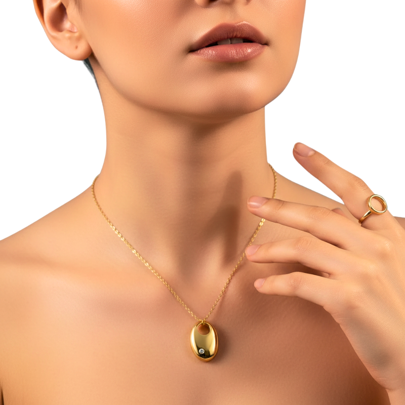 Gold necklace and ring on a model with a plain background