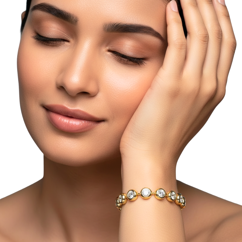 Woman wearing a gold bracelet with clear stones on a white background