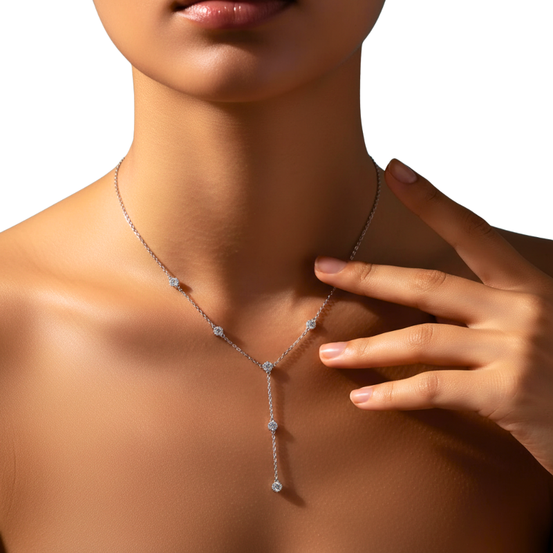 Woman wearing a delicate silver necklace with a close-up of the necklace on a neutral background