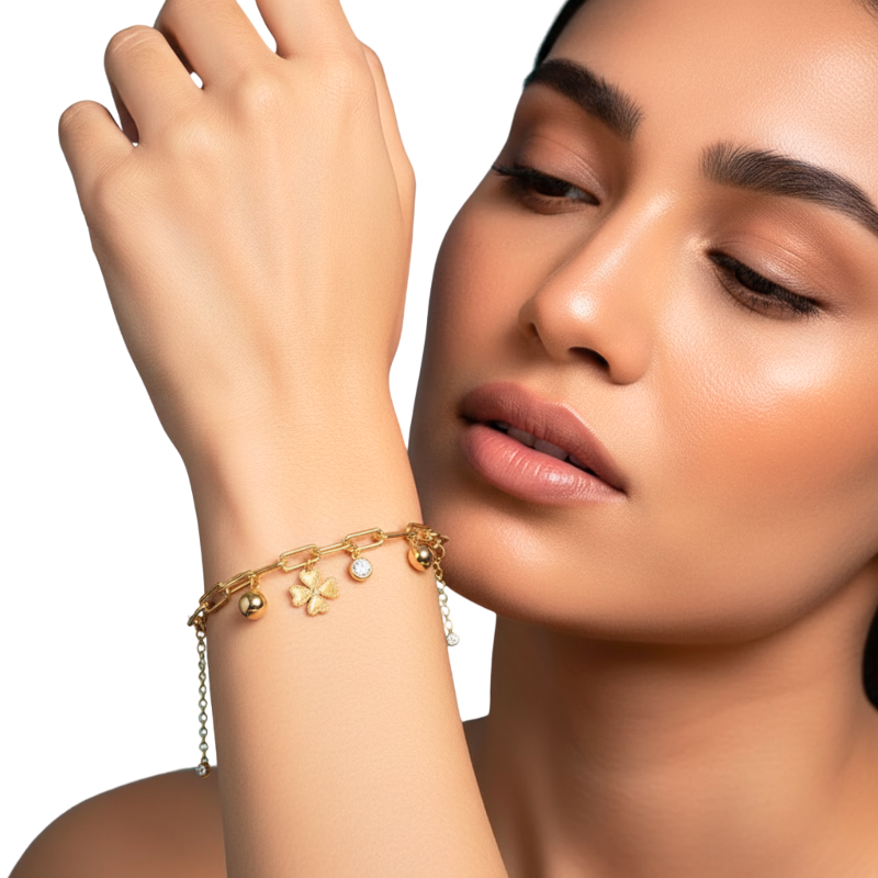 Woman wearing a gold bracelet with floral charms on a white background