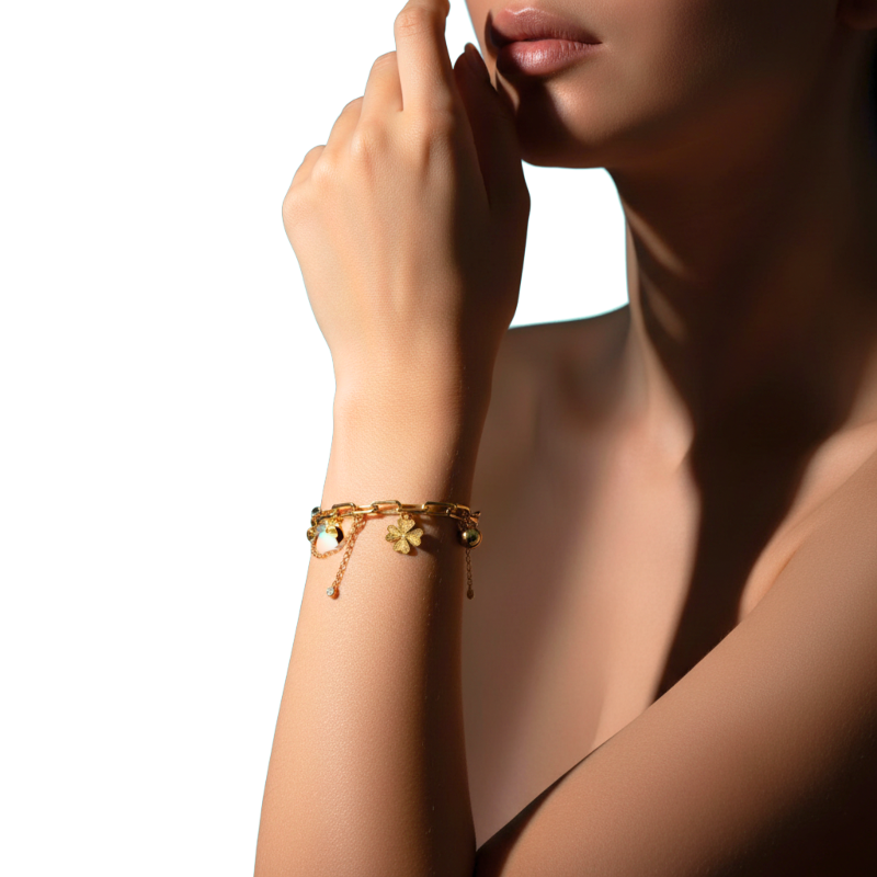 Gold bracelet on a woman's wrist with a neutral background