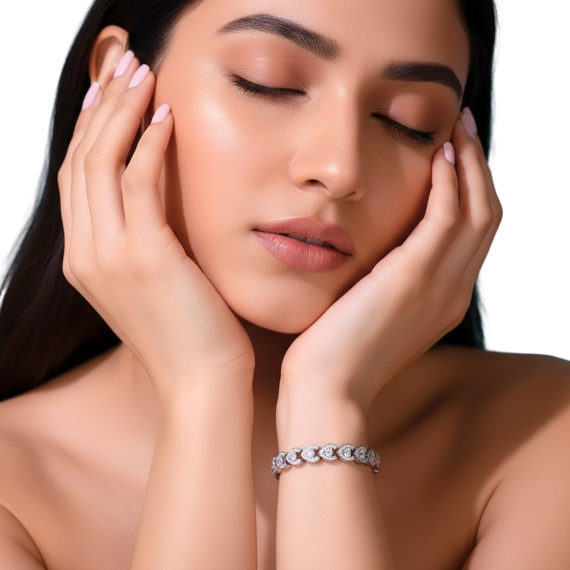 Woman with hands on face wearing a silver bracelet against a white background