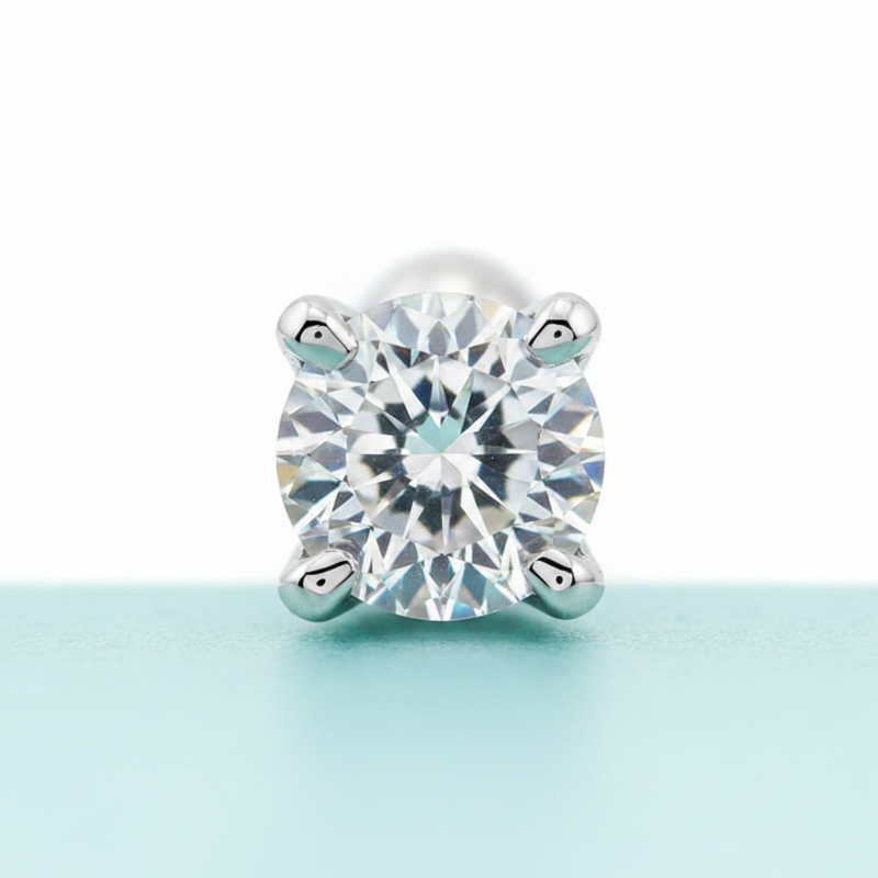 Single diamond earring on a light blue background