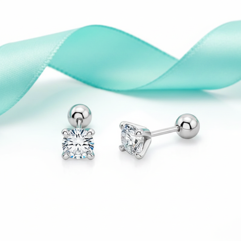 Pair of silver stud earrings with clear gemstones on a light blue ribbon background