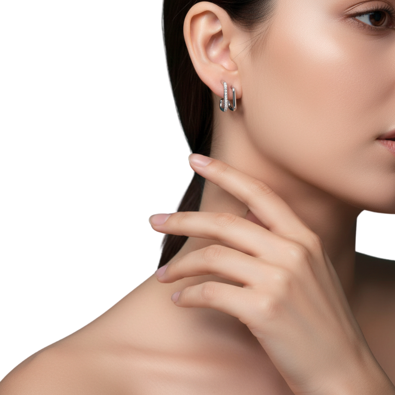 Close-up of a woman wearing silver hoop earrings with a neutral background