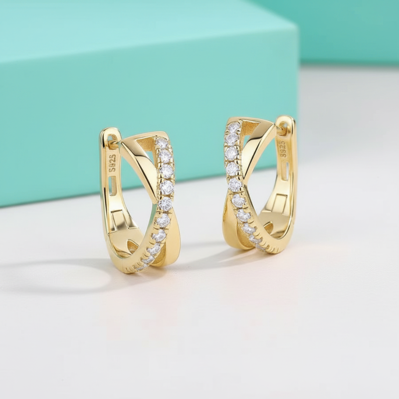 Gold hoop earrings with embedded diamonds on a light background