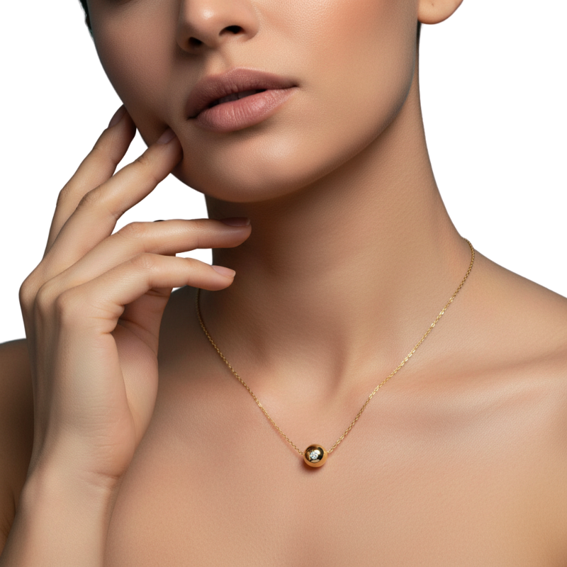 Close-up of a woman wearing a gold necklace with a green gemstone on a white background