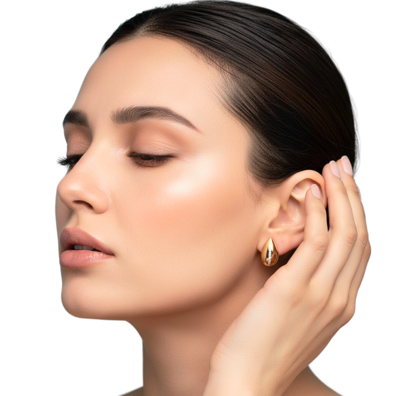 Woman adjusting a gold earring on a white background