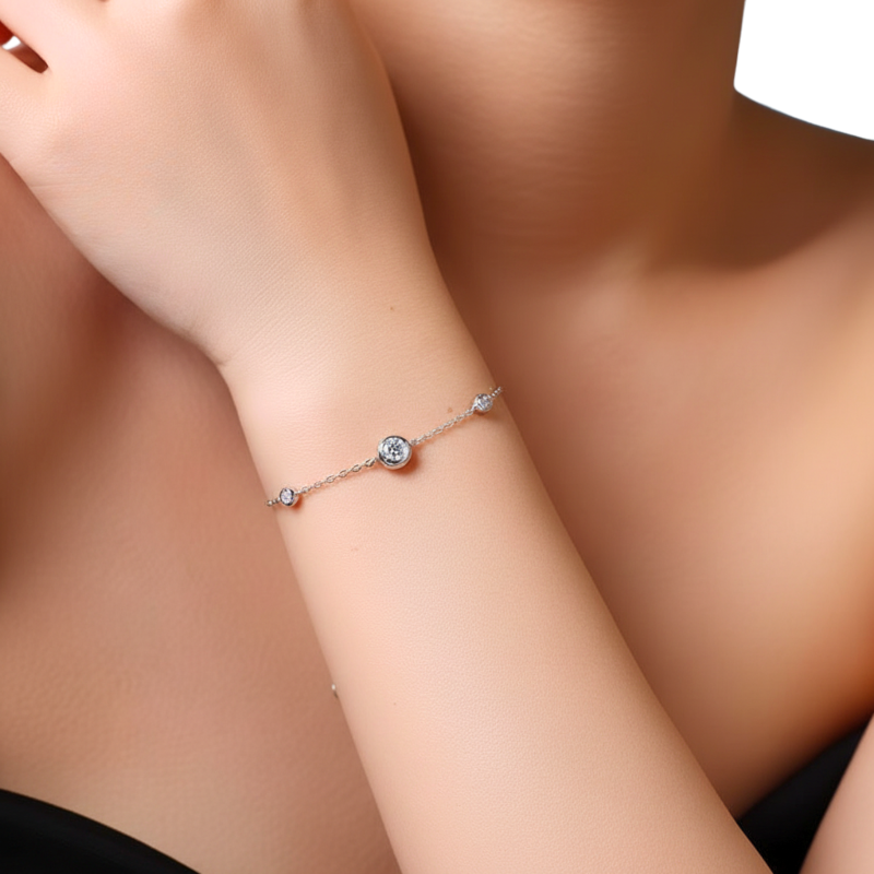 Silver bracelet with small stones on a person's wrist against a neutral background