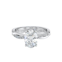 Silver ring with a large diamond and smaller diamonds on the band against a white background