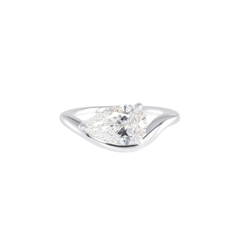A pear cut diamond solitaire engagement ring in a polished silver-colored metal, shown on a clean white background.