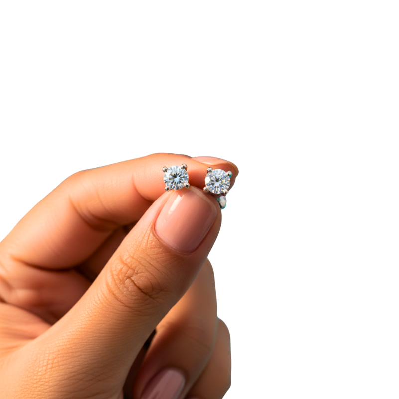 Diamond earrings held between fingers against a white background