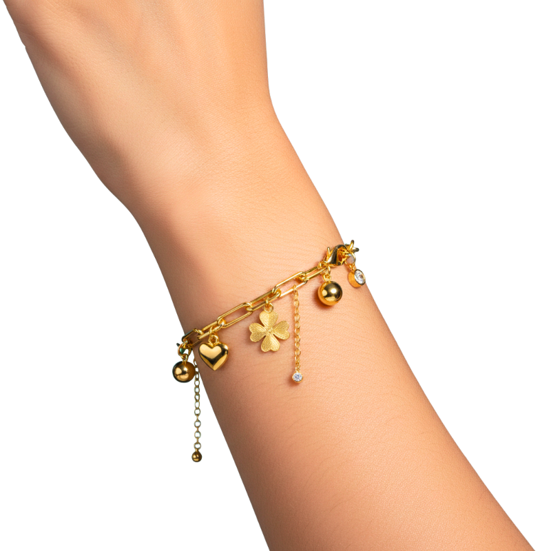 Gold bracelet with charms on a wrist against a white background