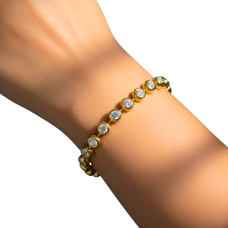 Gold bracelet with clear stones on a wrist against a white background