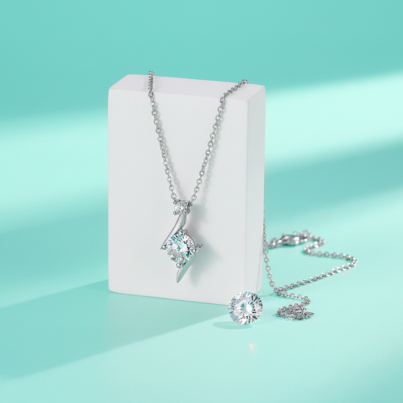 Silver necklace with a pendant on a white card against a light blue background