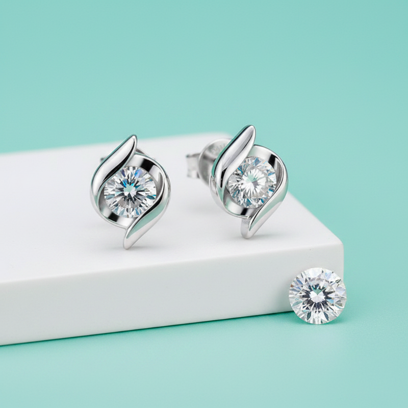 Silver earrings with clear gemstones on a light blue background
