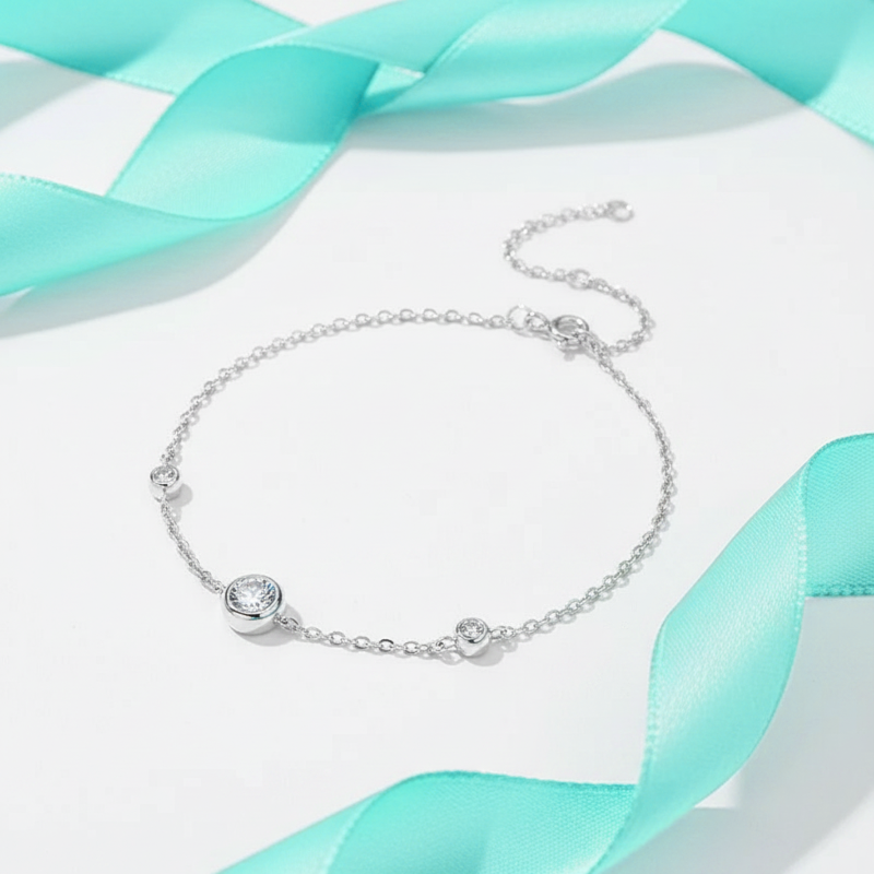 Silver bracelet with a gemstone on a light blue ribbon background