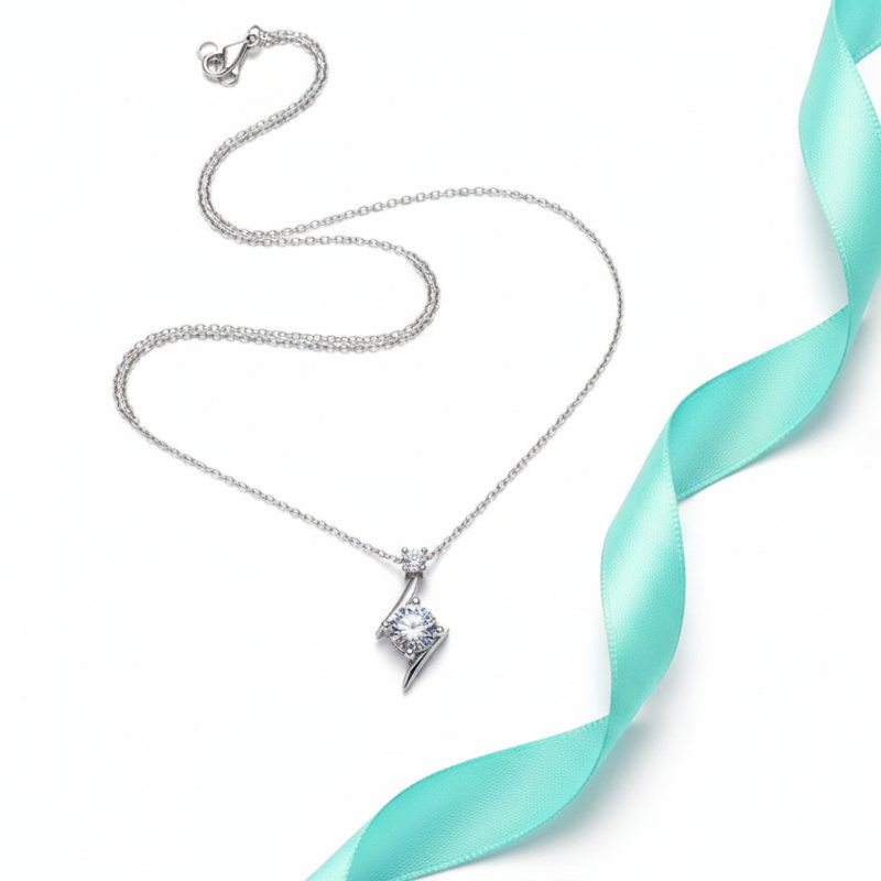 Silver necklace with a diamond pendant on a white background with a turquoise ribbon.