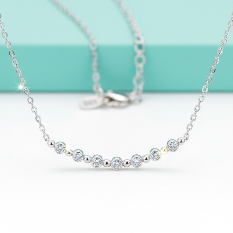 Silver necklace with small beads on a light blue background