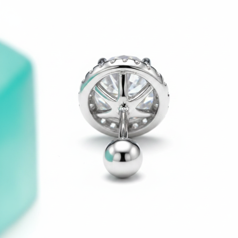 Silver charm with a turquoise accent on a white background