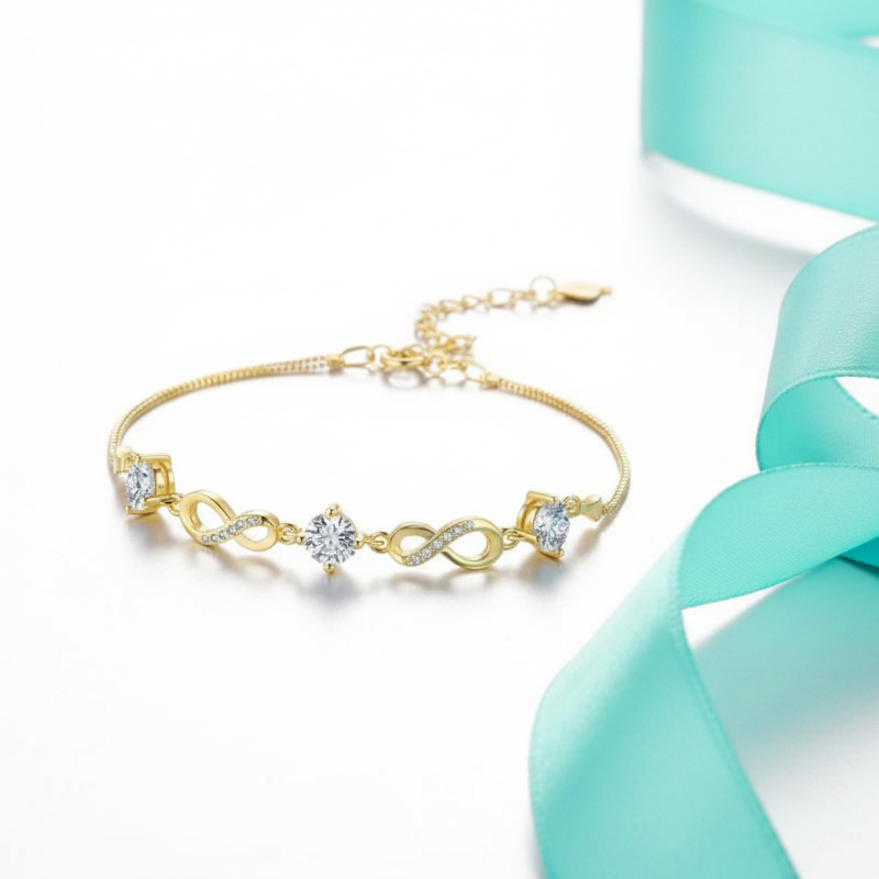 Gold bracelet with diamond accents on a light blue ribbon background