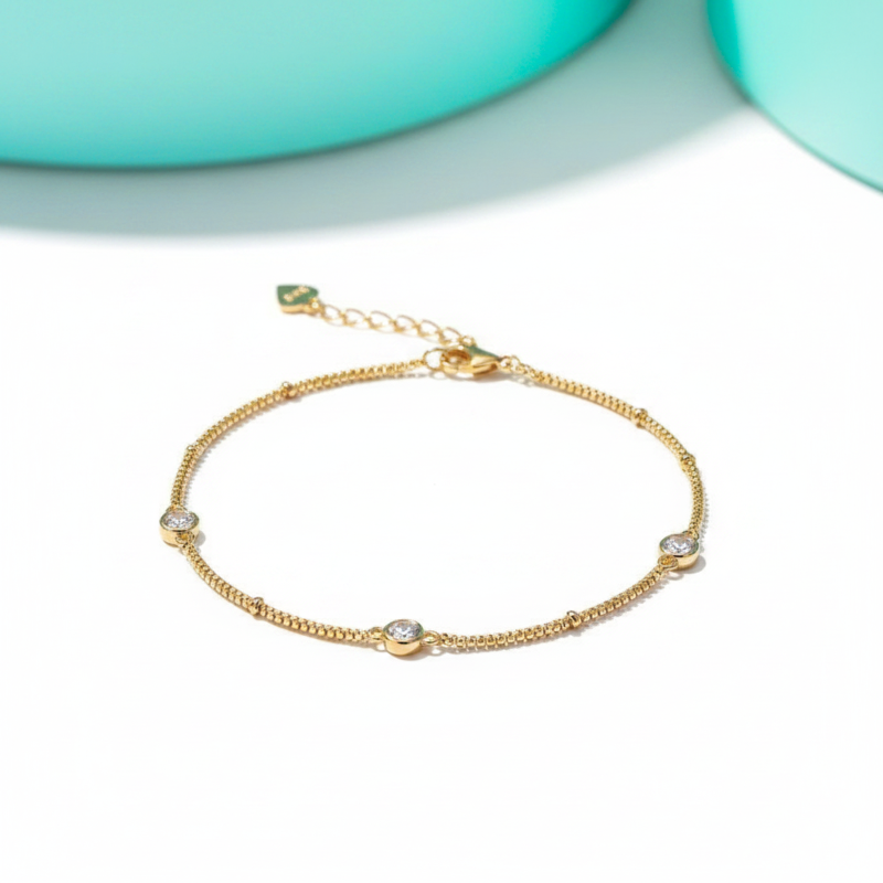 Gold bracelet with small diamonds on a light background