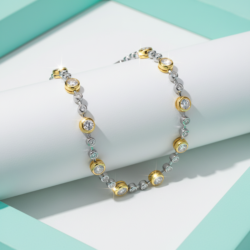 Pair of gold and silver hoop earrings on a light blue and white geometric background