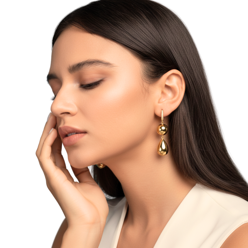 Woman wearing gold earrings with a neutral background