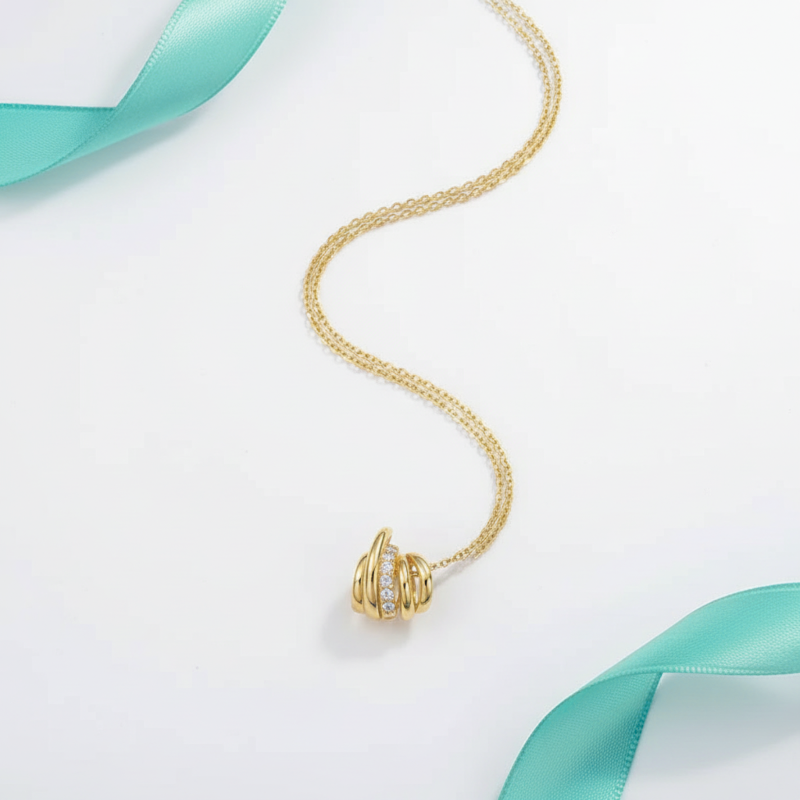 Gold necklace with a circular pendant on a light background