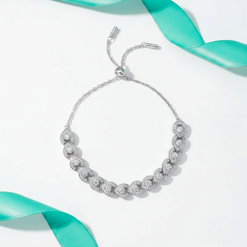 Silver bracelet with diamond accents on a white background with teal ribbons