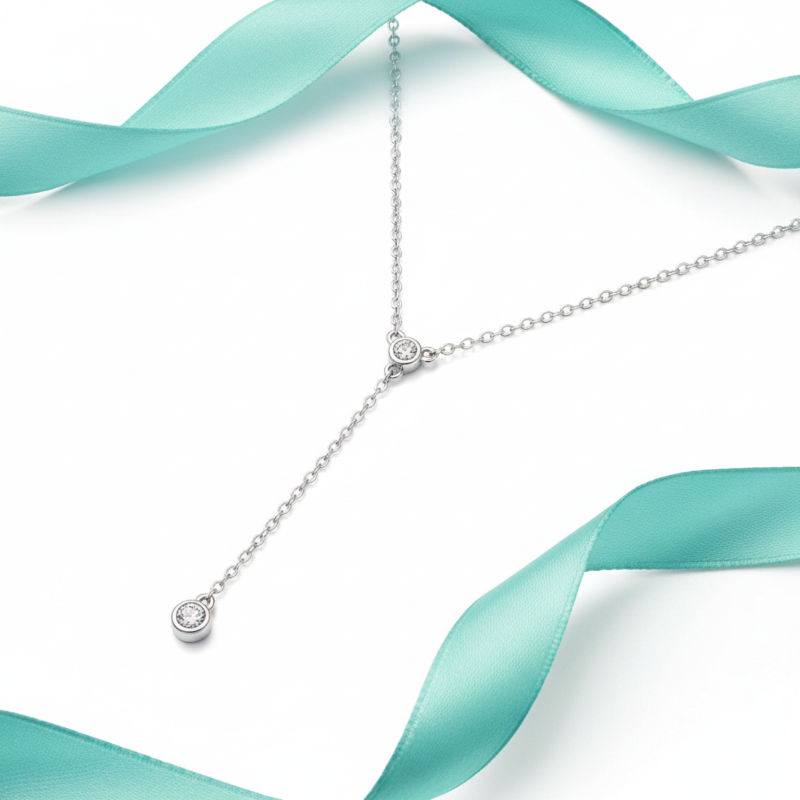 Silver necklace with heart-shaped pendant on a white background with teal ribbons