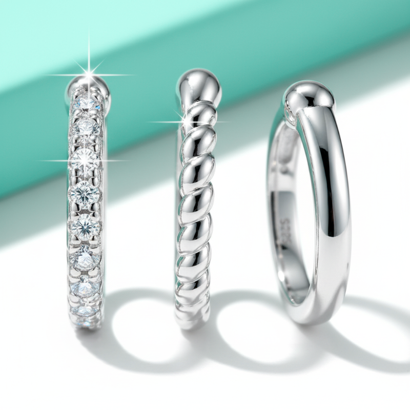 Three silver rings with different designs on a light blue and white background