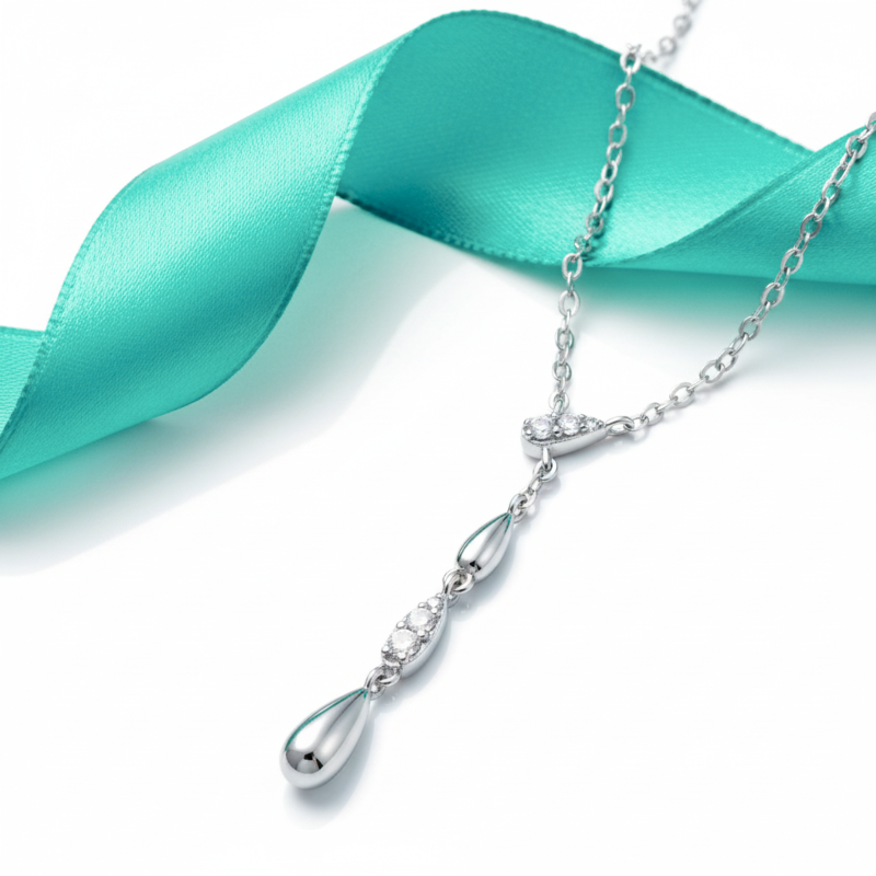 Silver necklace with a teardrop pendant on a turquoise ribbon