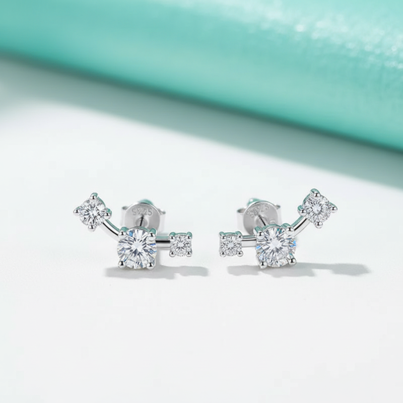Silver earrings with clear gemstones on a light blue and white background