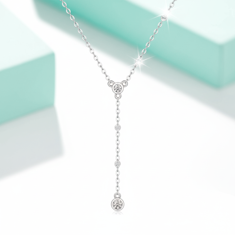 Silver necklace with diamond pendants on a light green and white background