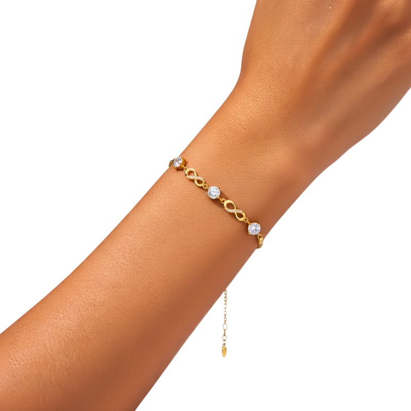 Gold bracelet with diamond accents on a wrist against a white background