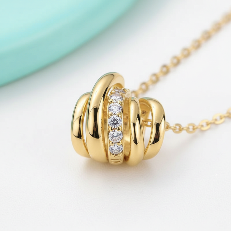 Gold necklace with interlocking rings and embedded diamonds on a light background
