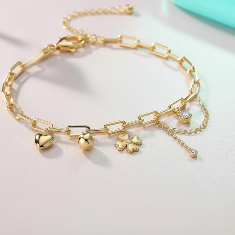 Gold bracelet with charms on a light gray background