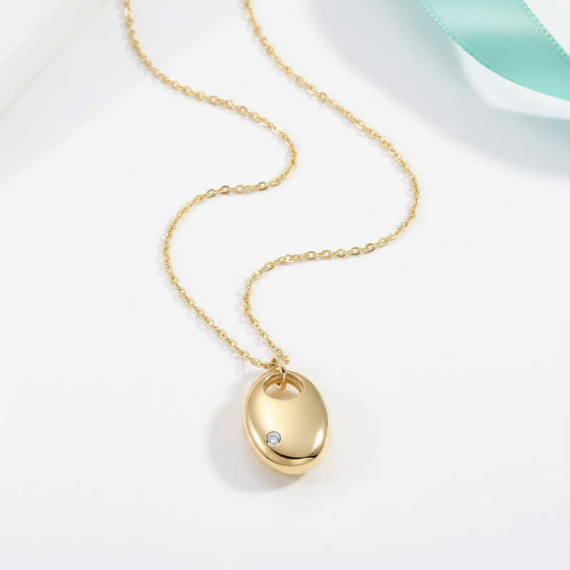 Gold necklace with a pendant on a light gray background
