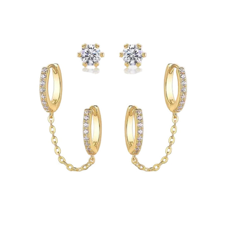 Gold hoop earrings with chain and clear gemstones on a white background