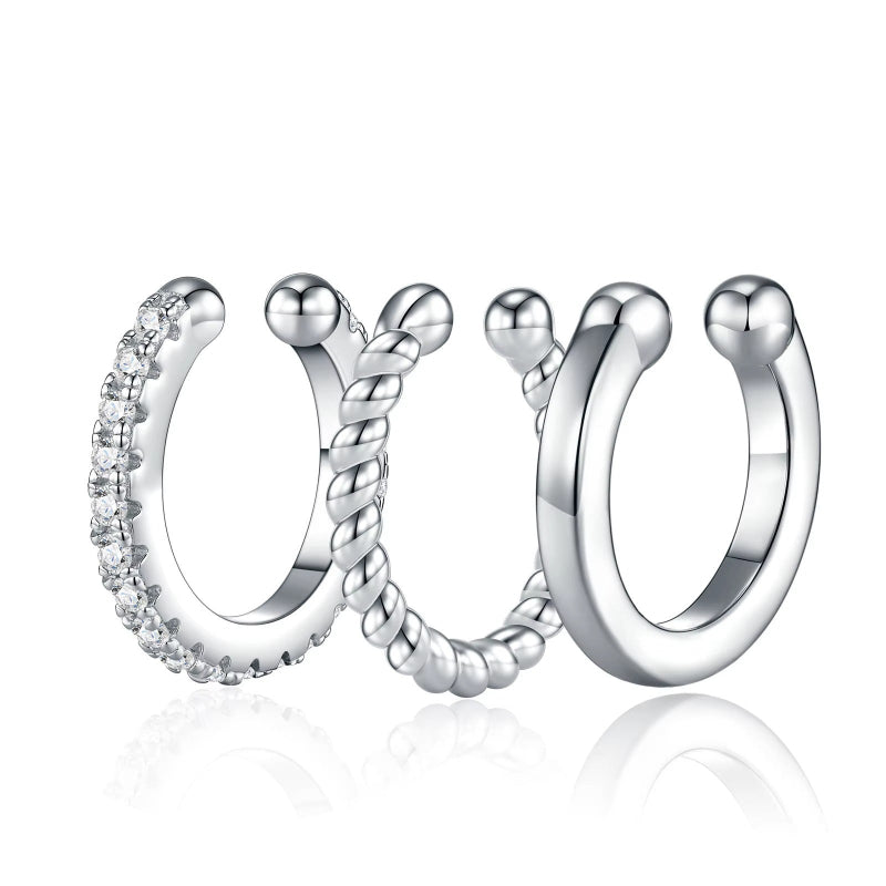 Three silver hoop earrings with different designs on a white background