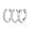 Three silver hoop earrings with different designs on a white background